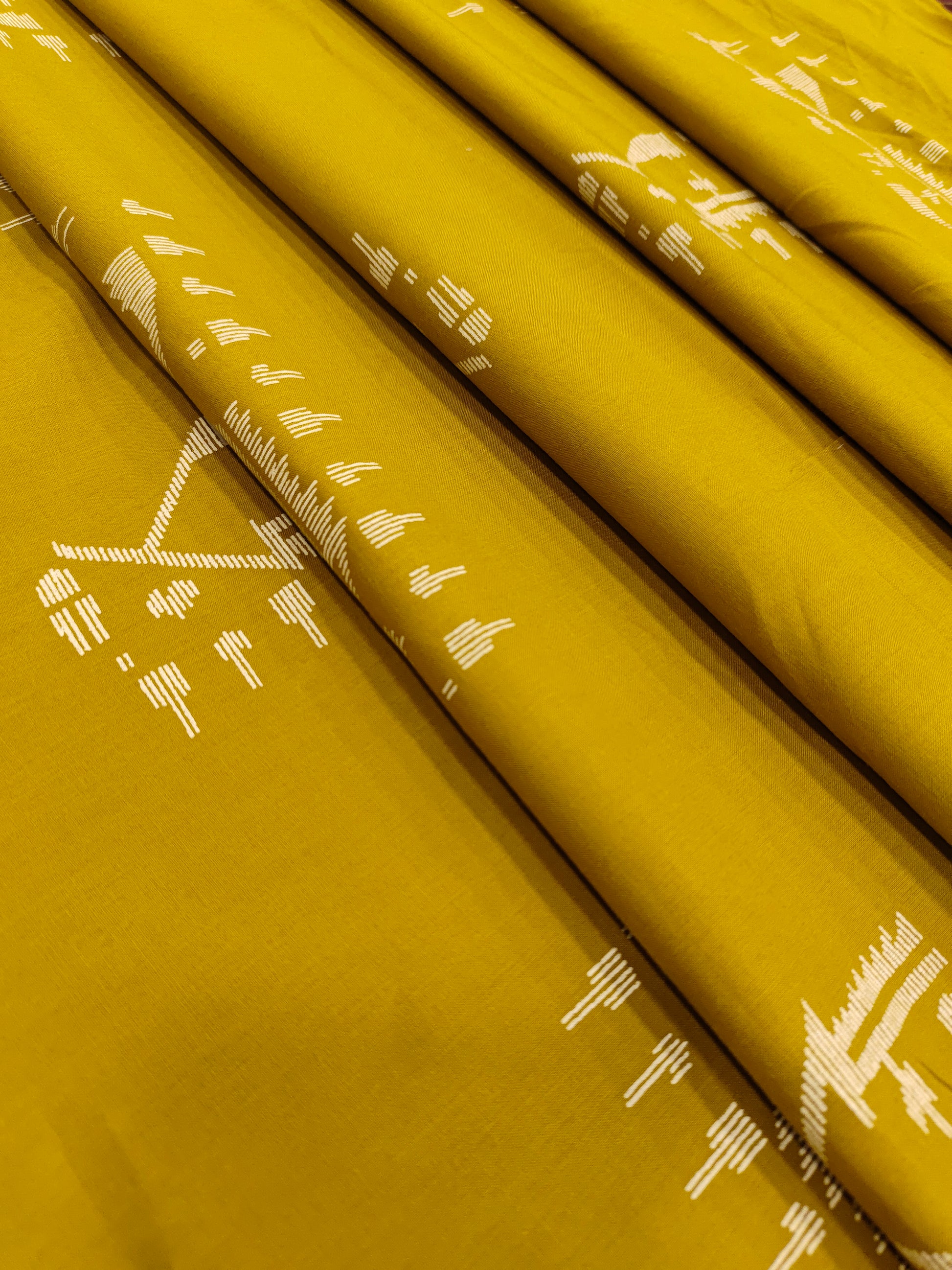 Mustard color cotton fabric with jamdani print in white.