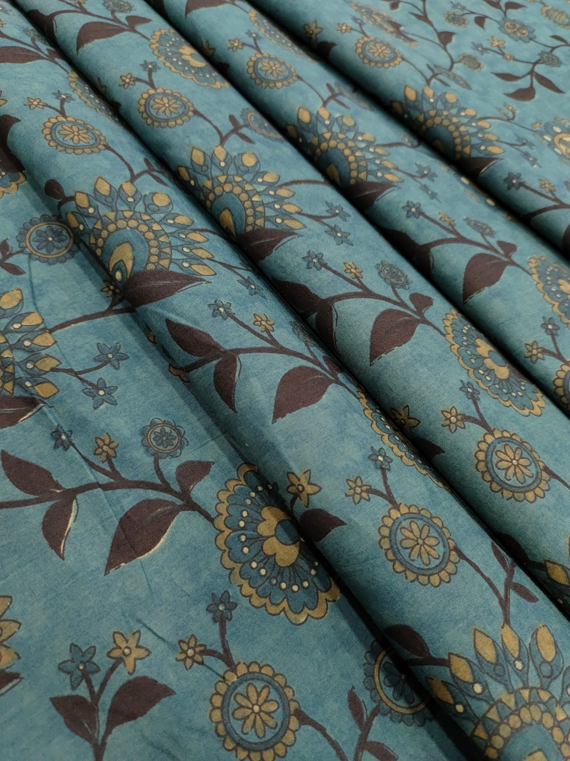 Cotton peacock green fabric jaal print with black maroon mustard.