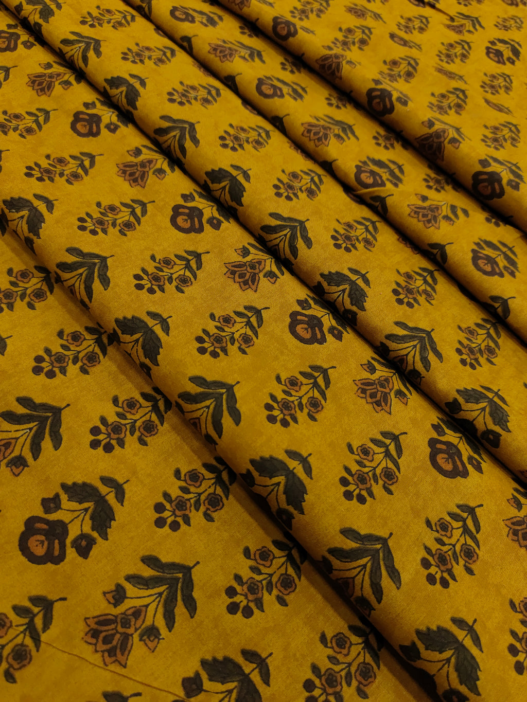 Cotton bagh print on mustard base with brown and green colors in 2 forms of butti.
