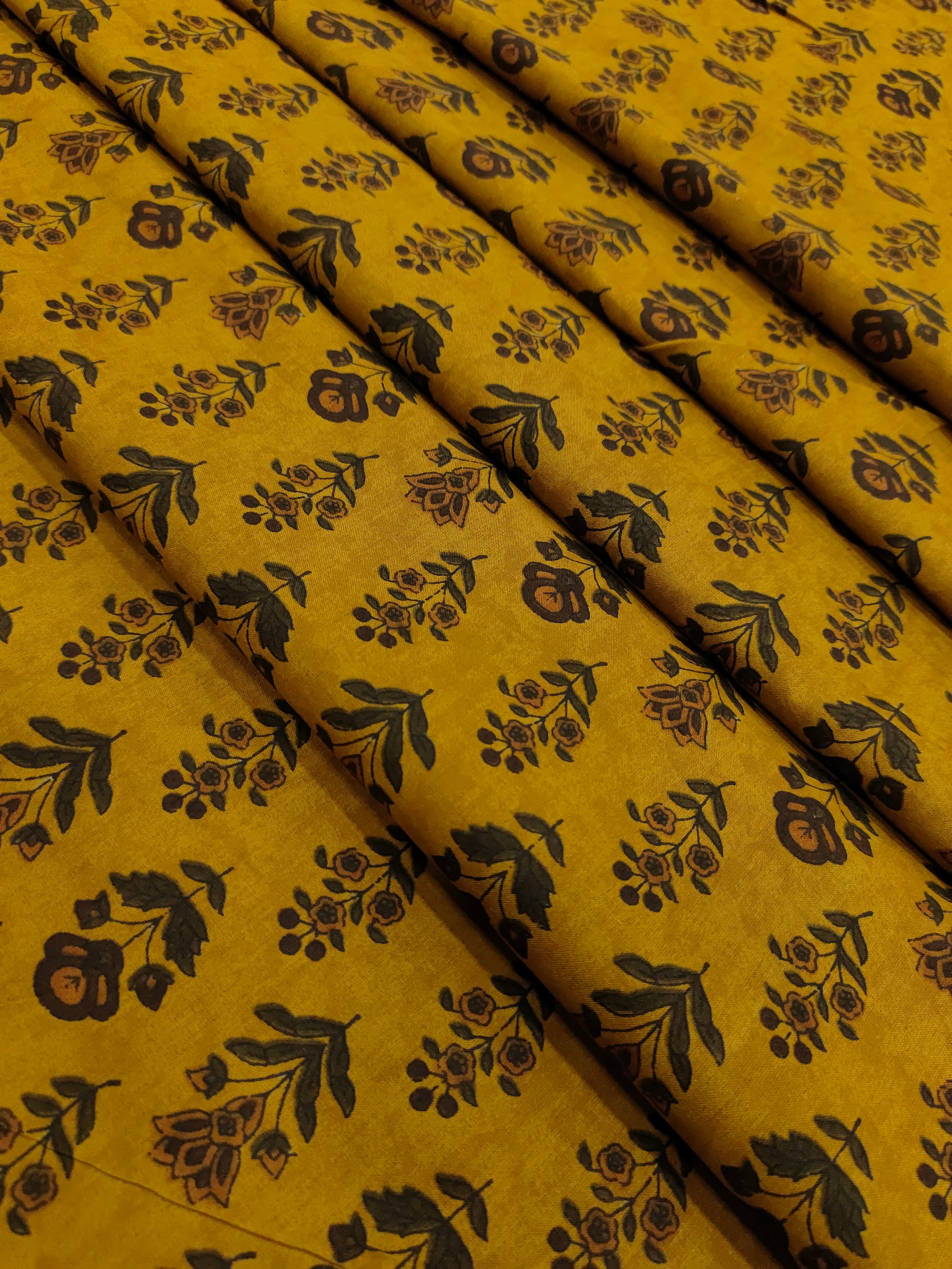 Cotton bagh print on mustard base with brown and green colors in 2 forms of butti.