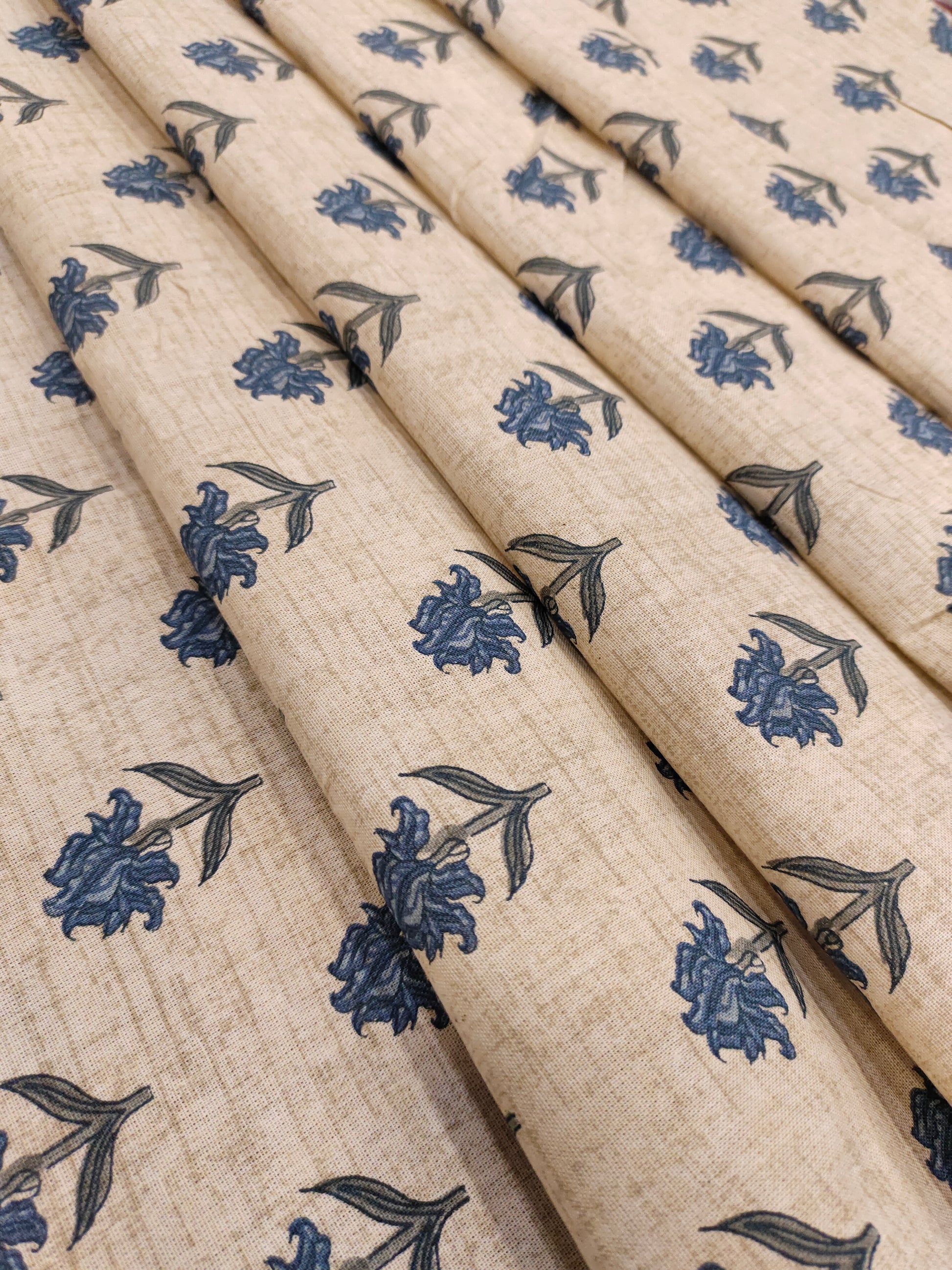 Beige flex cotton printed with blue small butti.