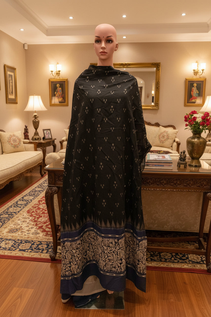 Black cotton fabric with blue daman print in hand.