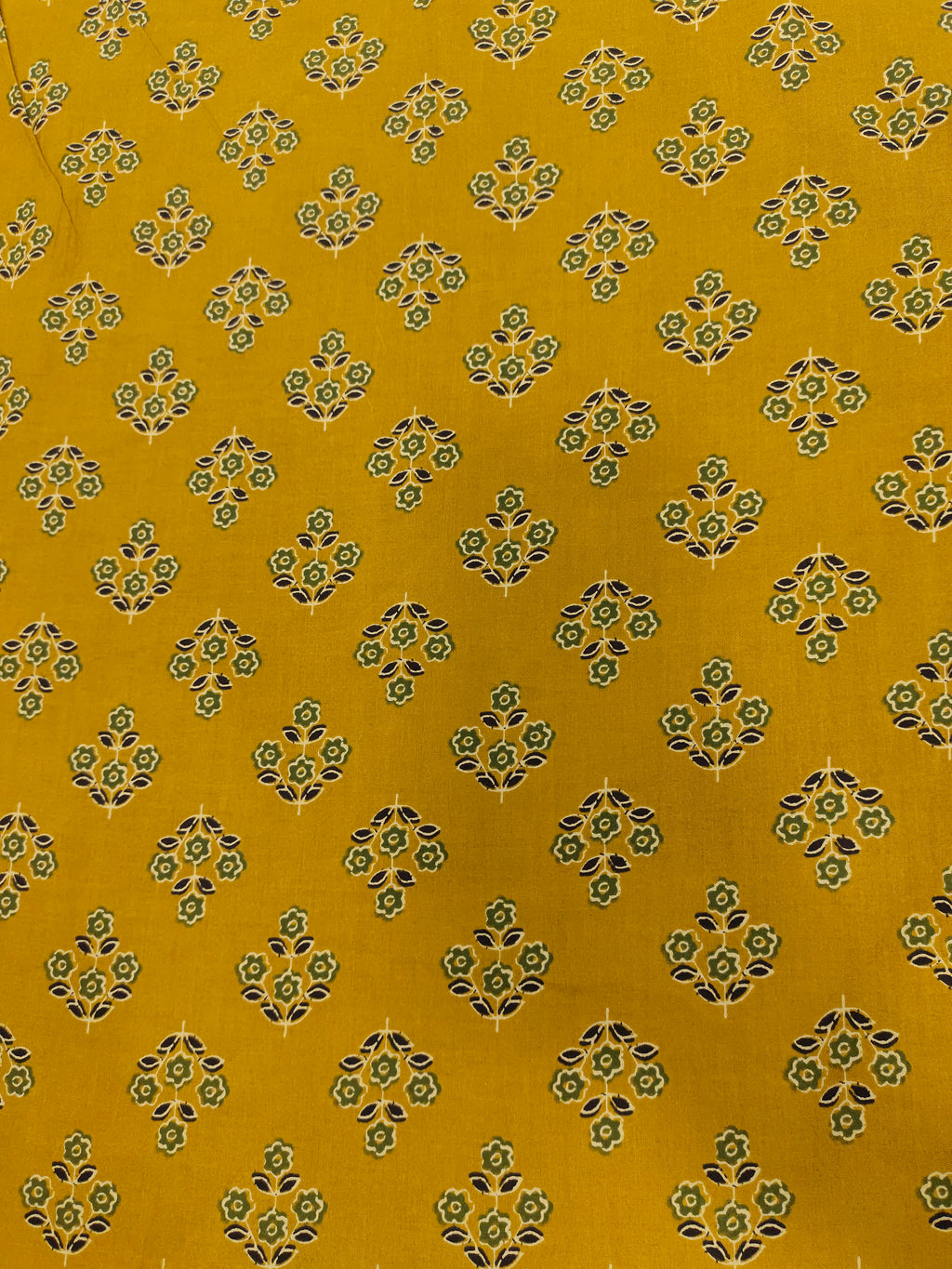 mustard cotton fabric with green black and beige butti.