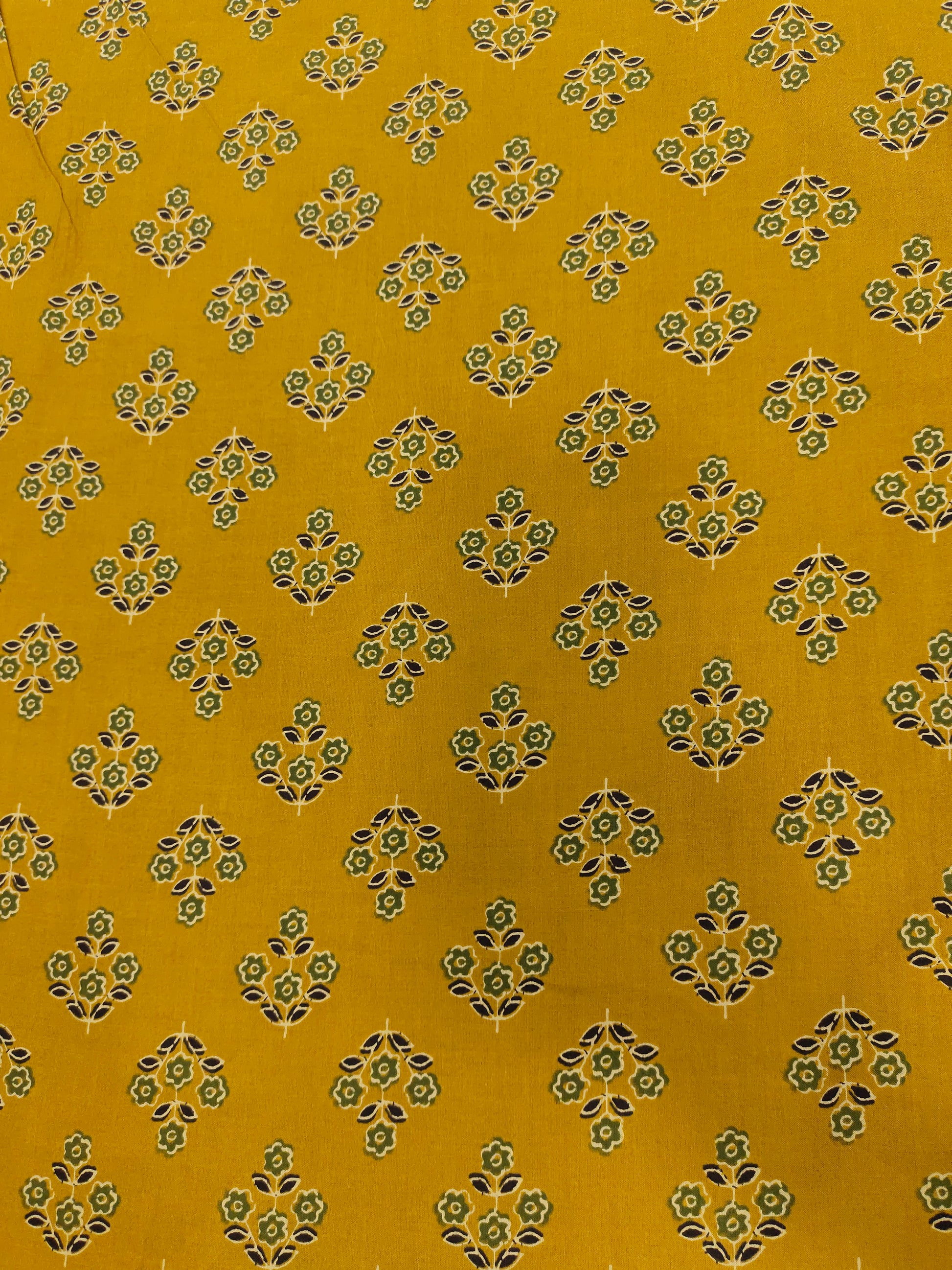 mustard cotton fabric with green black and beige butti.