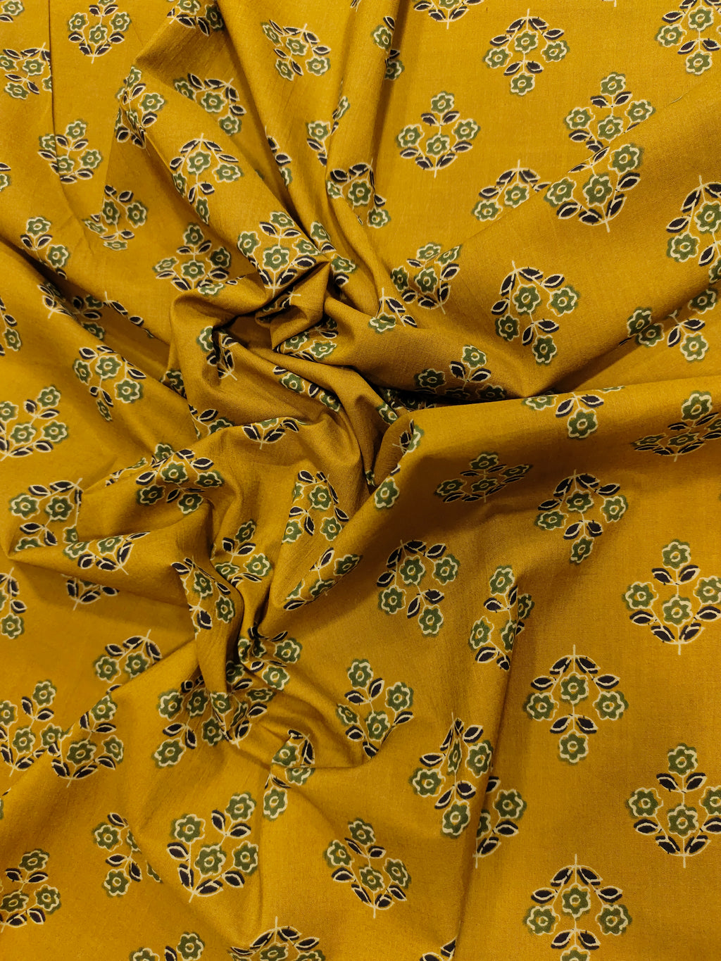 mustard cotton fabric with green black and beige butti.