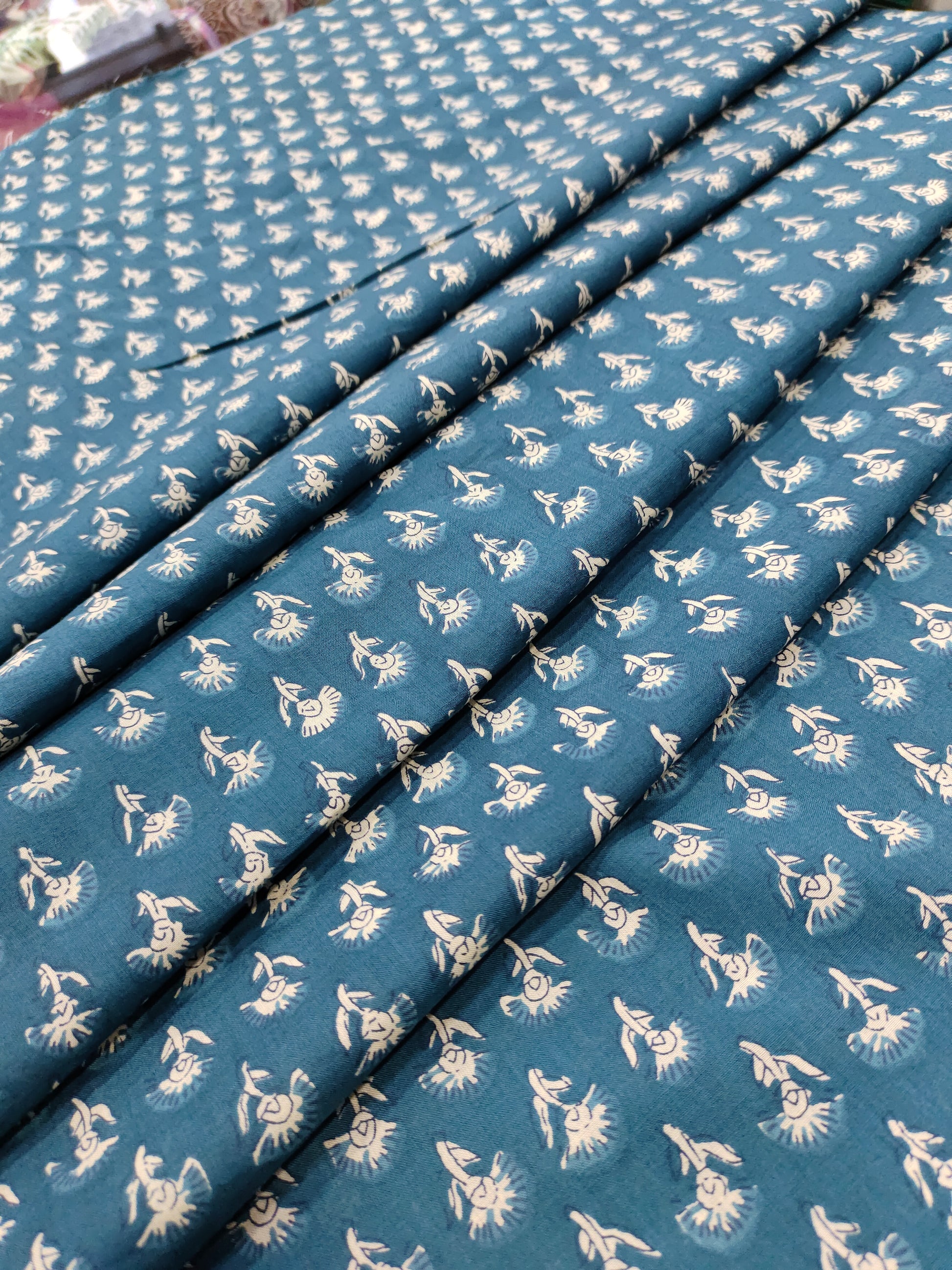 Bluish green fabric with small off-white buttis on cotton fabric.