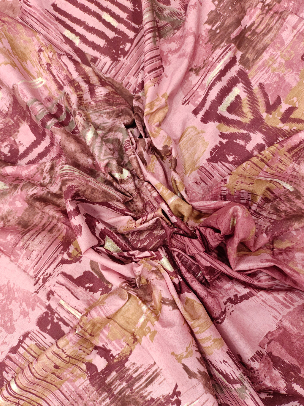 Cotton abstract print with little gold foil in maroon and pink colors.