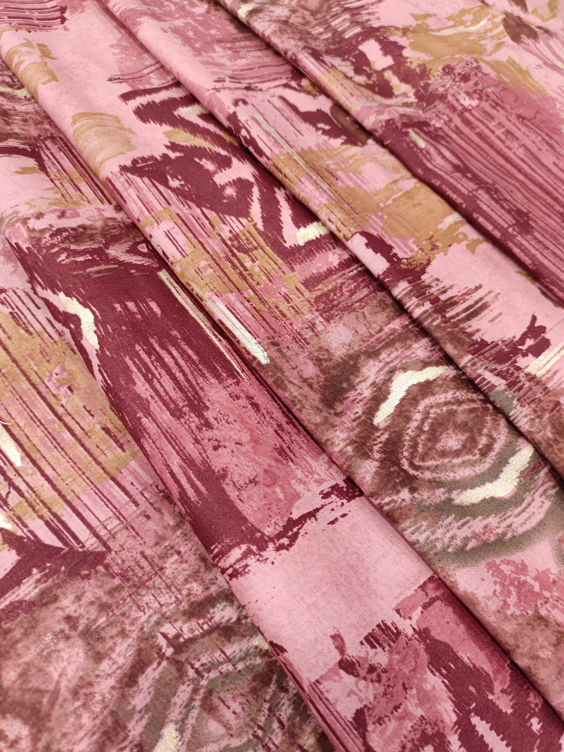 Cotton abstract print with little gold foil in maroon and pink colors.