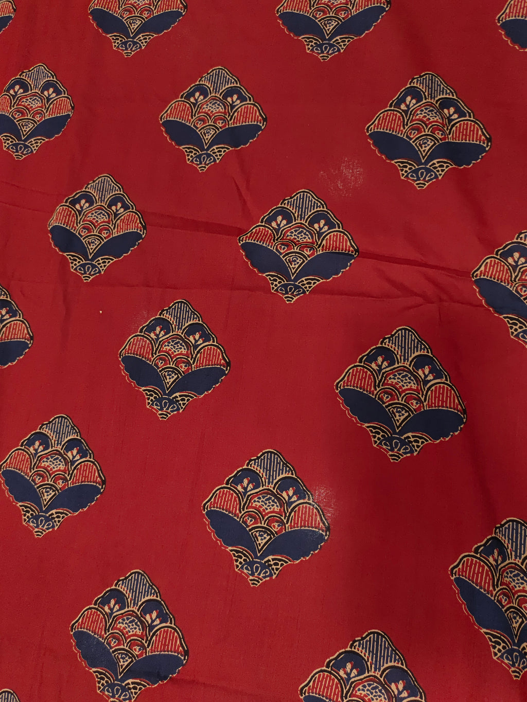 Maroon cotton fabric with floral motifs in blue and beige.